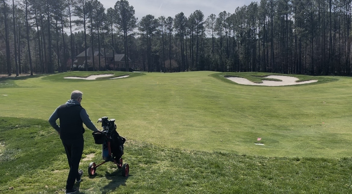 Golfer walking the fairway with a Bag Boy Nitron push cart
